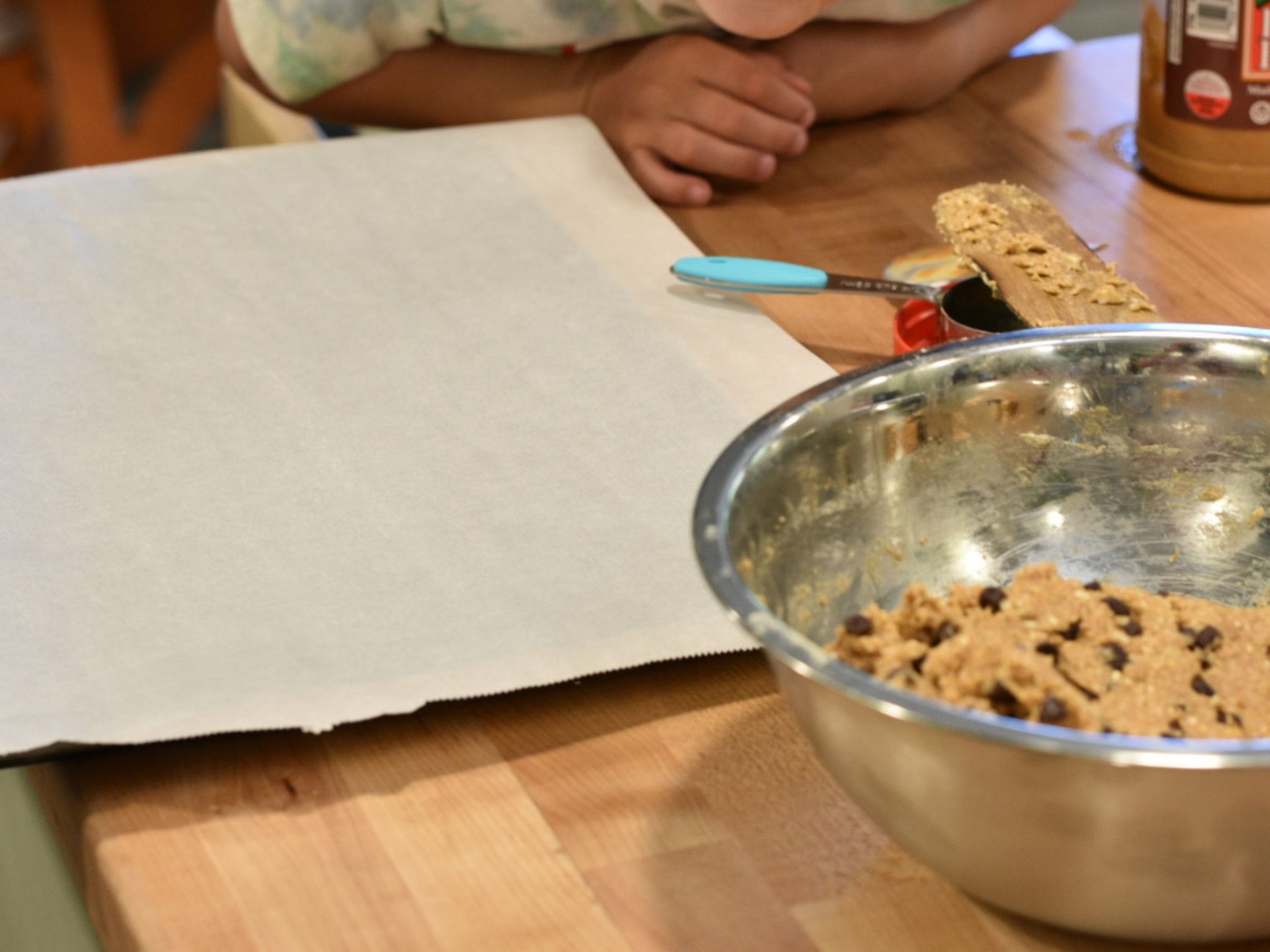 a pan with parchment paper next to a peanut butter batter