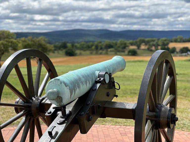 Close-up view of a historic cannon at Antietam Battlefield with scenic landscape.