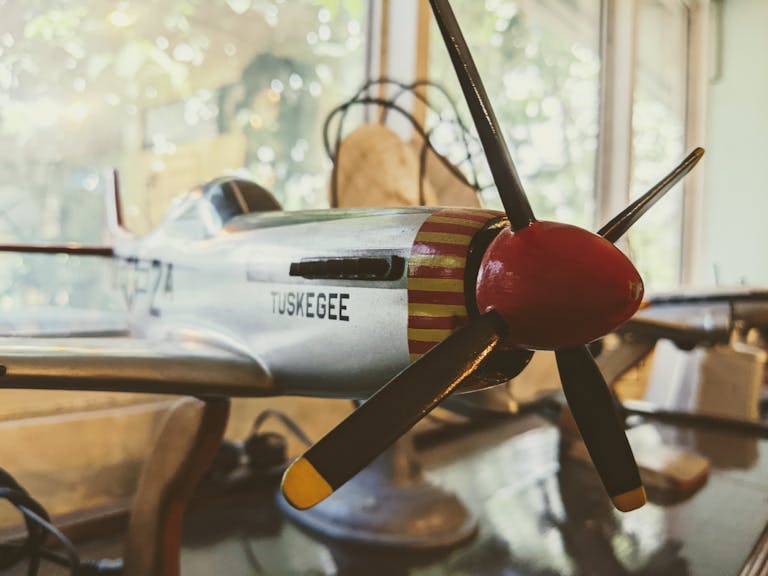 Detailed view of a Tuskegee model airplane, highlighting its metallic finish and propeller.